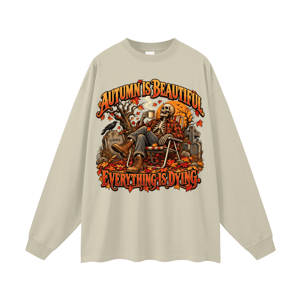 Beige Autumn Is Beautiful long-sleeve T-shirt, front view with a seated skeleton, fall leaves and orange lettering.