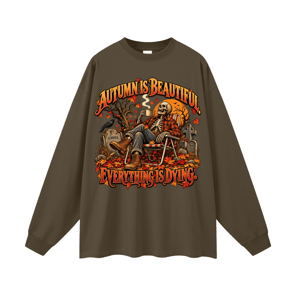 Dark brown Autumn Is Beautiful long-sleeve T-shirt, front view with a seated skeleton, fall leaves and orange lettering.