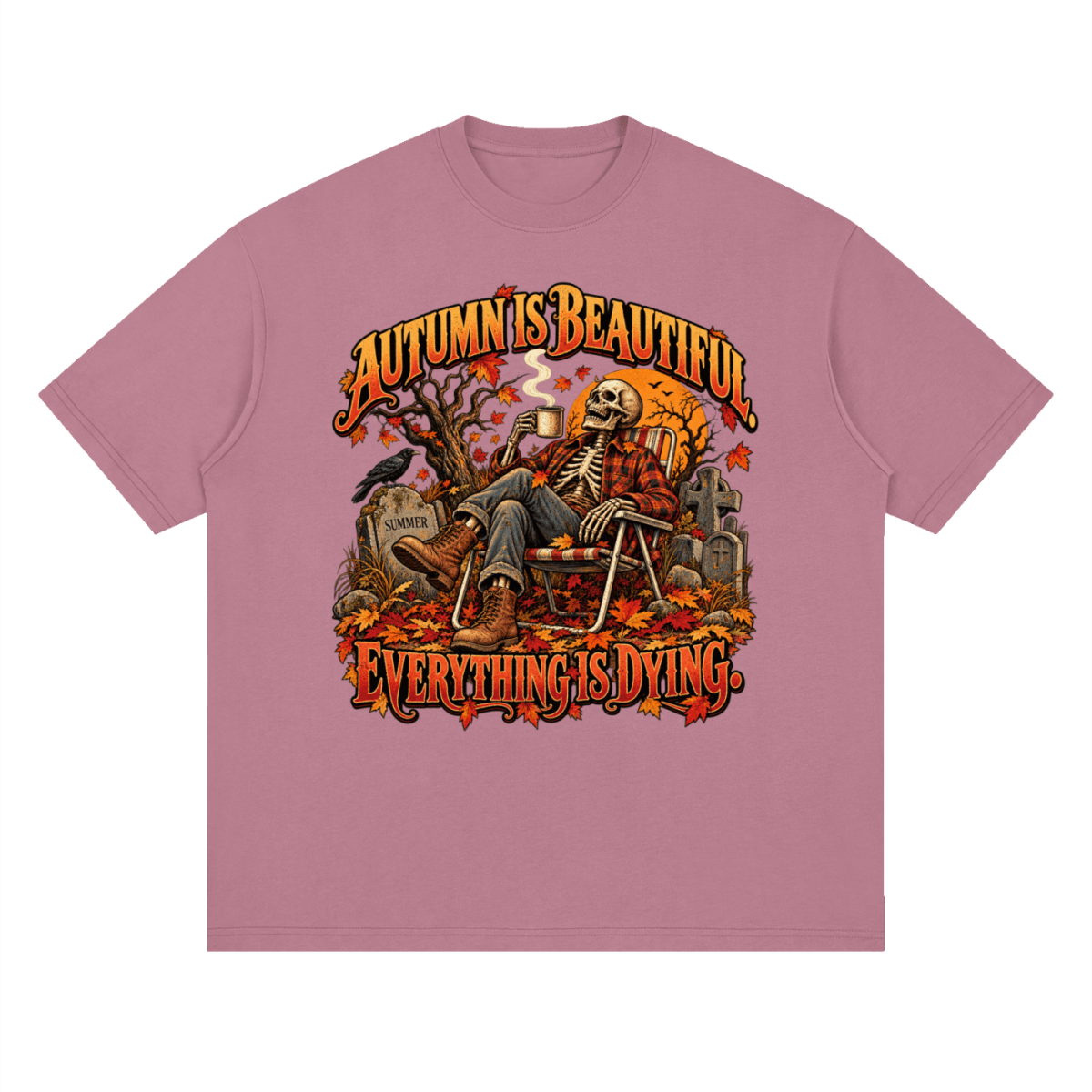 Dusty pink Autumn Is Beautiful drop-shoulder T-shirt, front view with a seated skeleton, fall leaves and orange lettering.