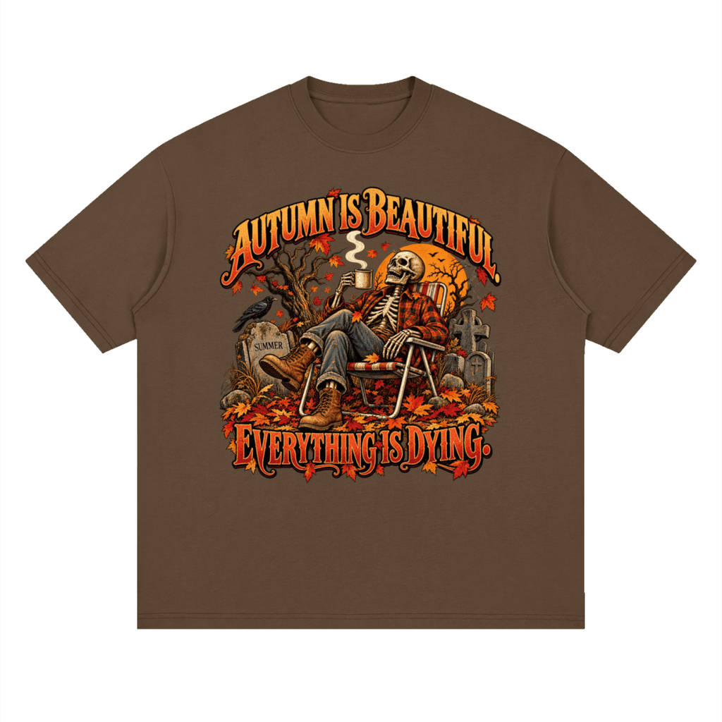 Brown Autumn Is Beautiful drop-shoulder T-shirt, front view with a seated skeleton, fall leaves and orange lettering.
