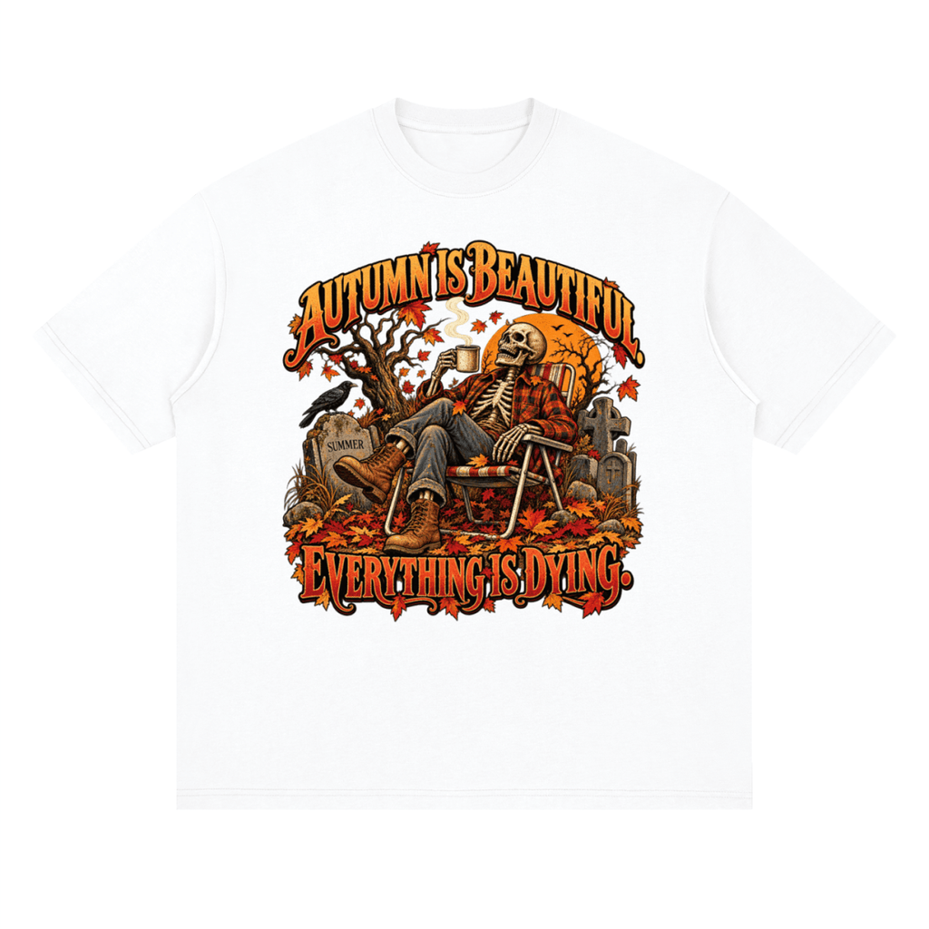 White Autumn Is Beautiful drop-shoulder T-shirt, front view with a seated skeleton, fall leaves and orange lettering.