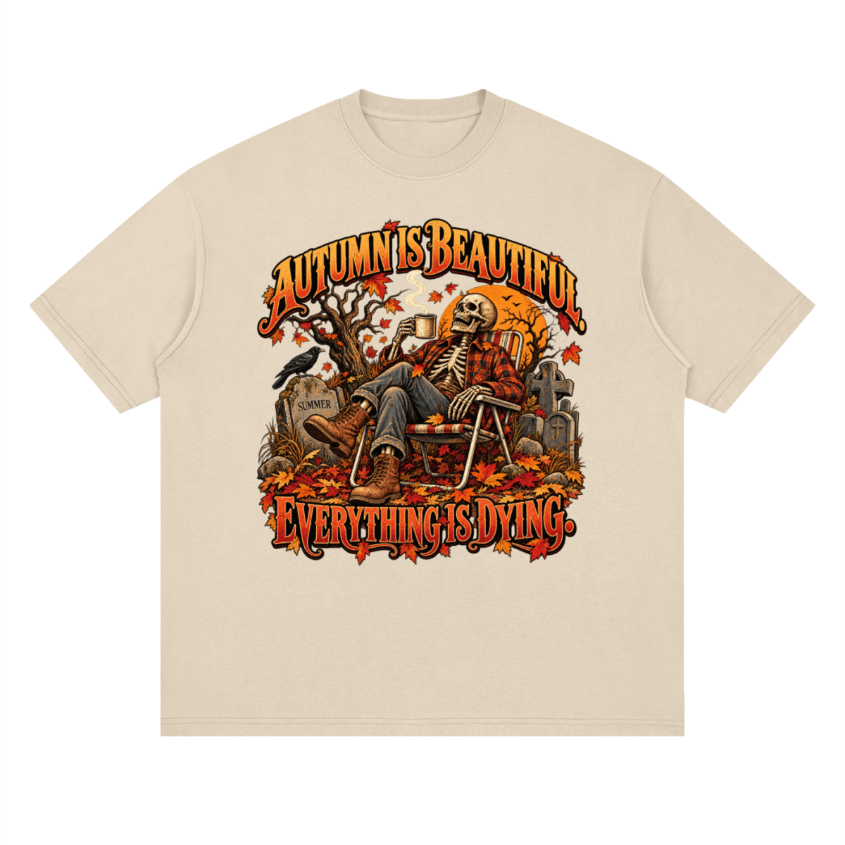 Cream Autumn Is Beautiful drop-shoulder T-shirt, front view with a seated skeleton, fall leaves and orange lettering.