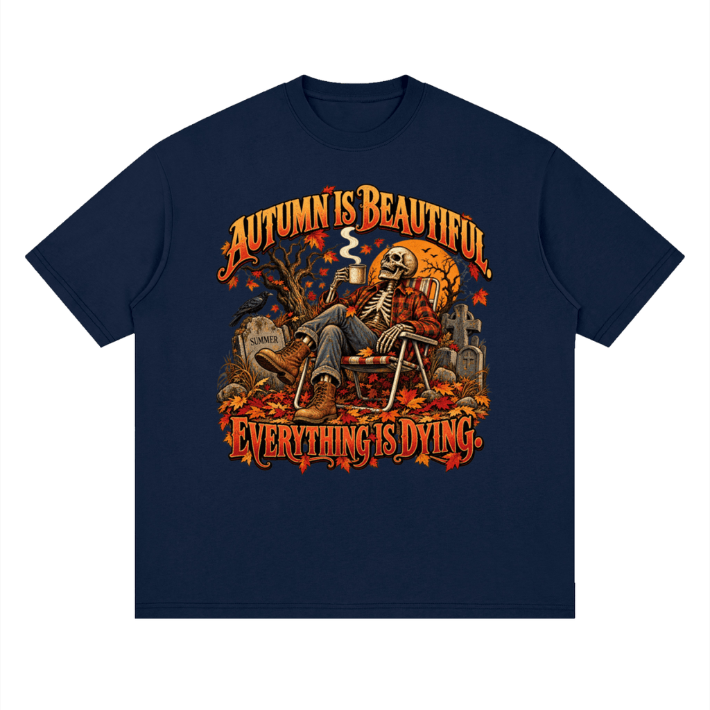 Navy blue Autumn Is Beautiful drop-shoulder T-shirt, front view with a seated skeleton, fall leaves and orange lettering.
