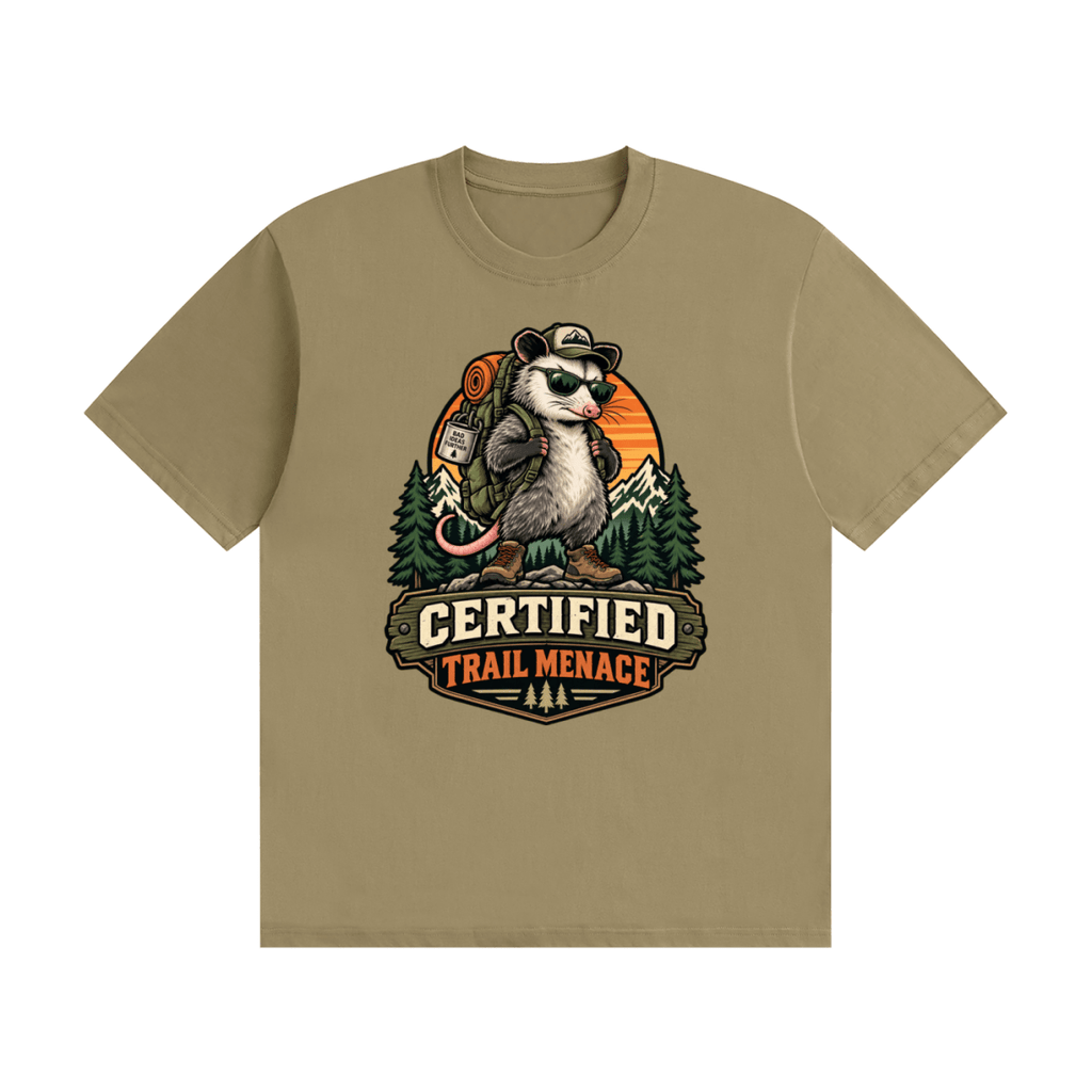 Khaki cotton T-shirt, front view with a hiking possum with sunglasses and backpack against mountains and an orange sunset.