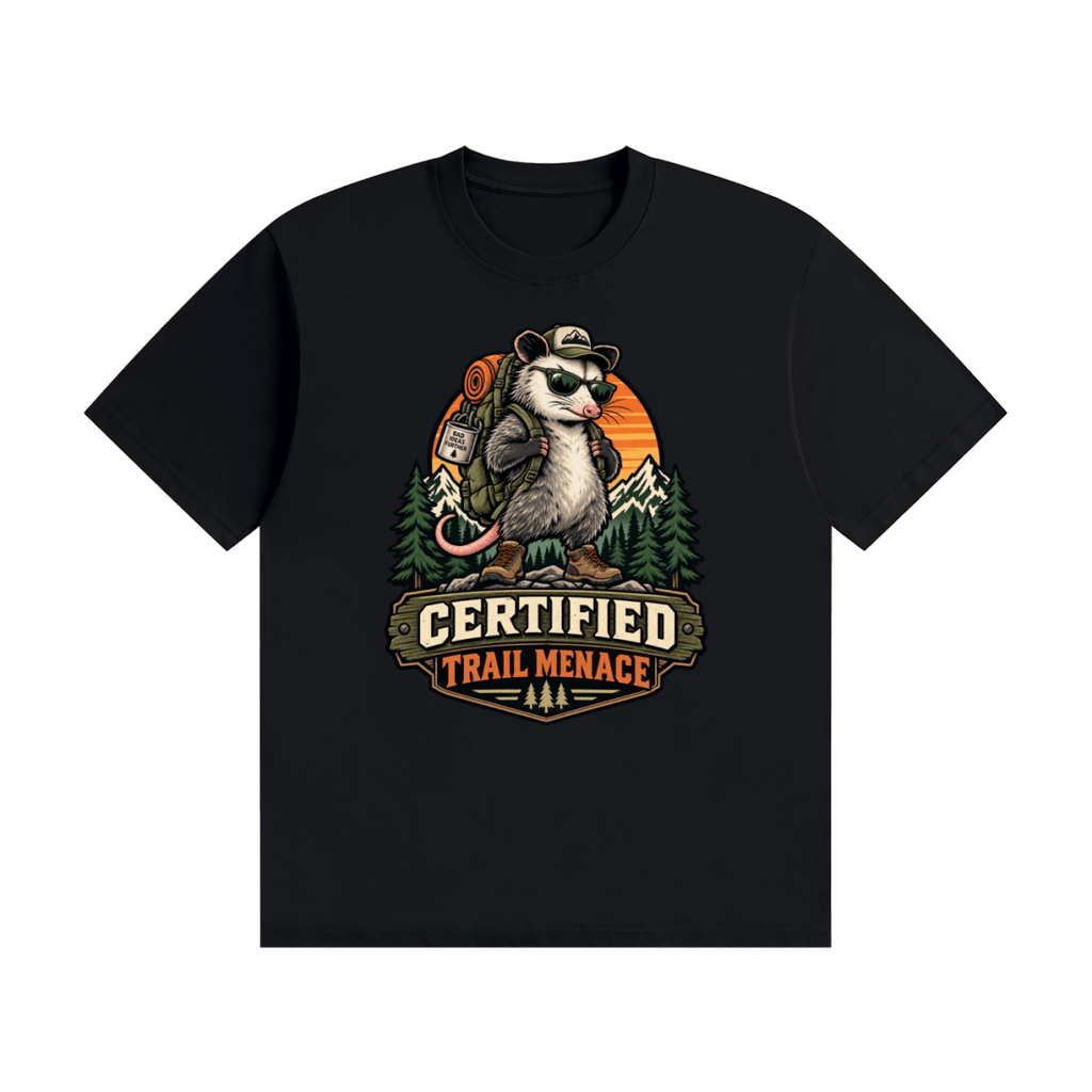 Black cotton T-shirt, front view with a hiking possum with sunglasses and backpack against mountains and an orange sunset.