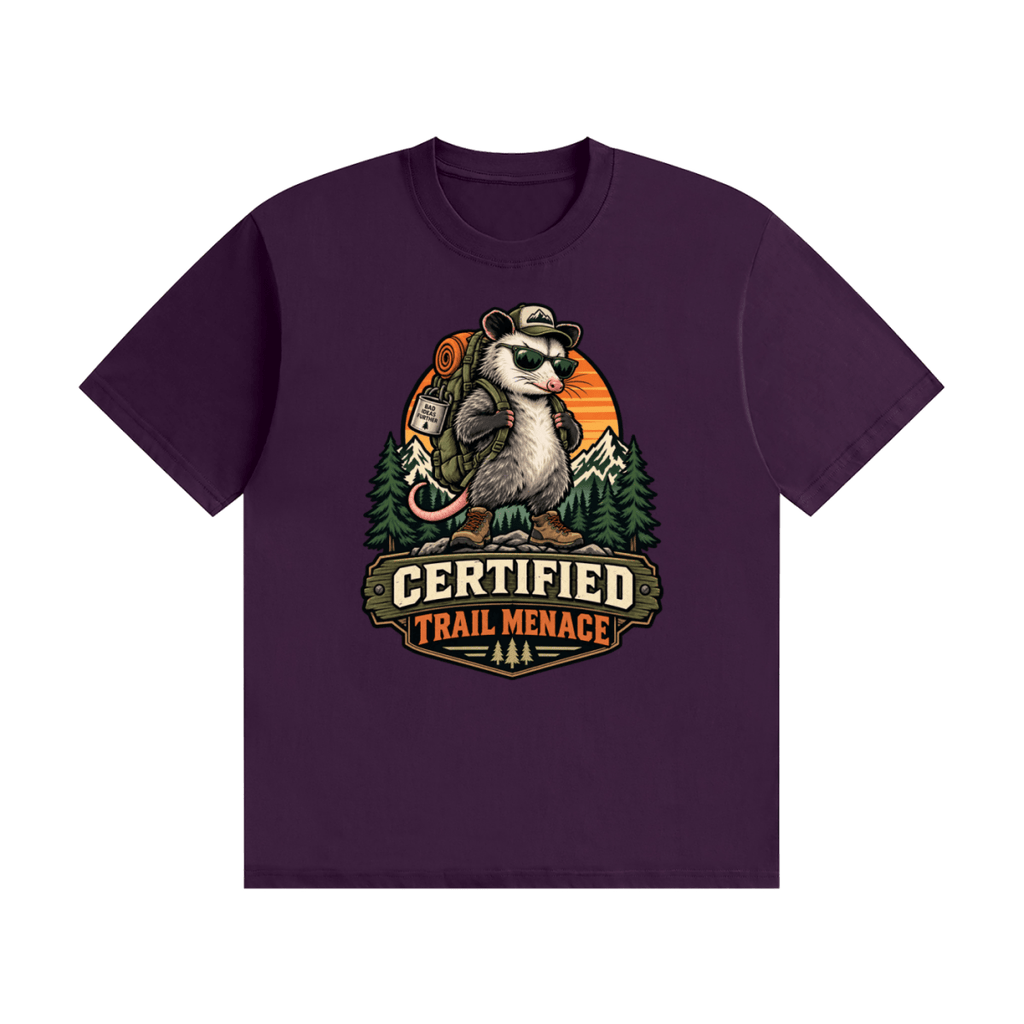 Purple cotton T-shirt, front view with a hiking possum with sunglasses and backpack against mountains and an orange sunset.