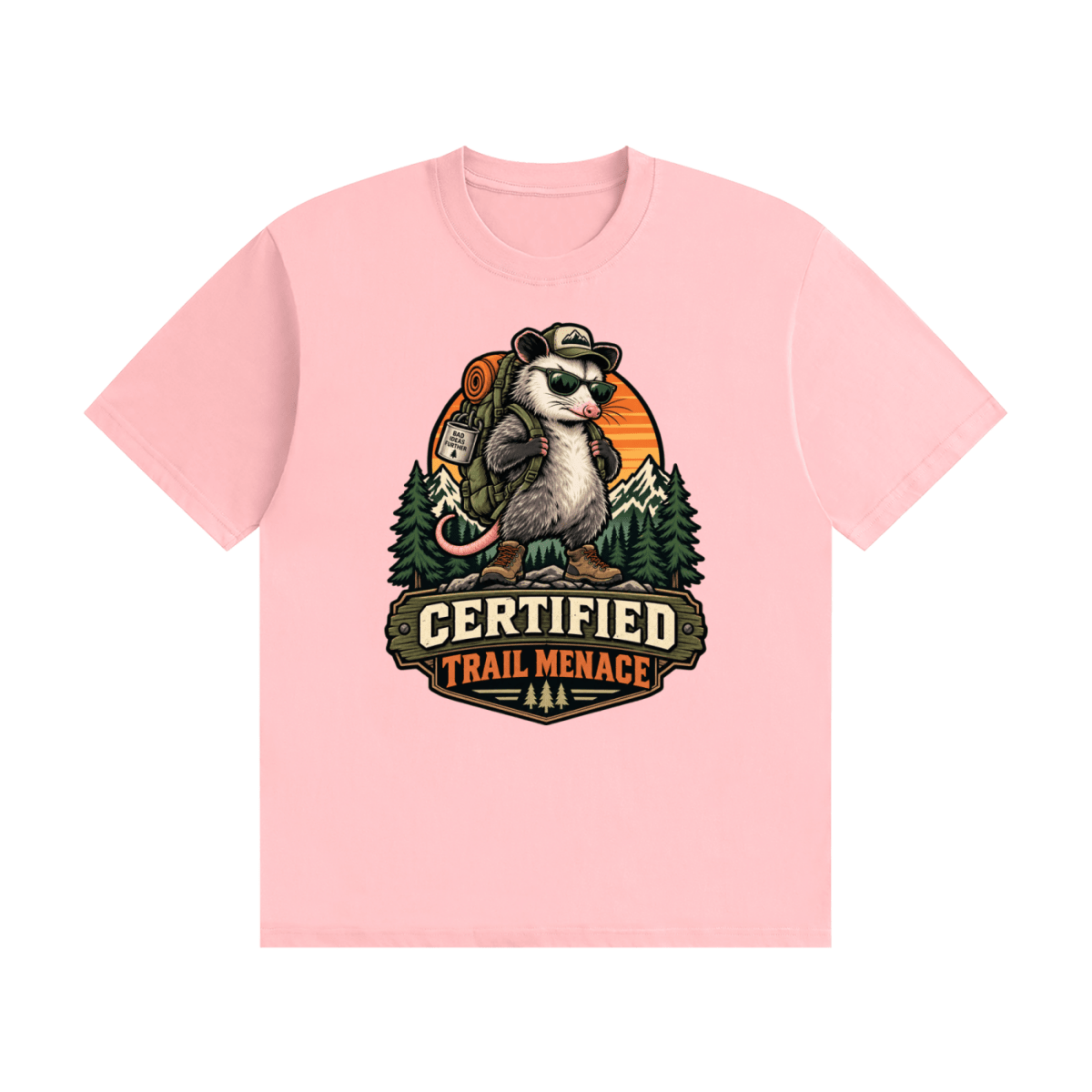 Pink cotton T-shirt, front view with a hiking possum with sunglasses and backpack against mountains and an orange sunset.