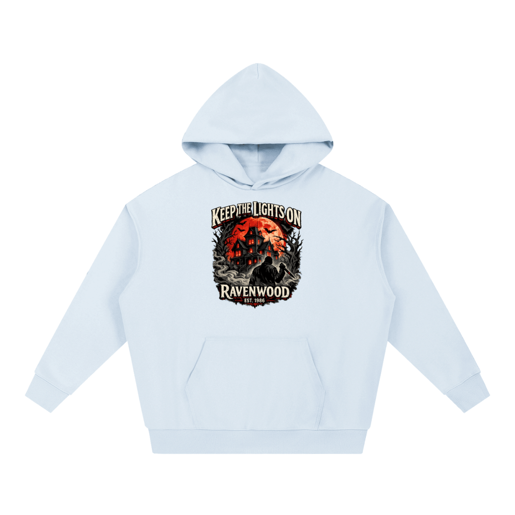 Light blue heavyweight hoodie, front view with a haunted house, orange moon and knife-holding silhouette with Keep the Lights On and Ravenwood Est. 1986 lettering.