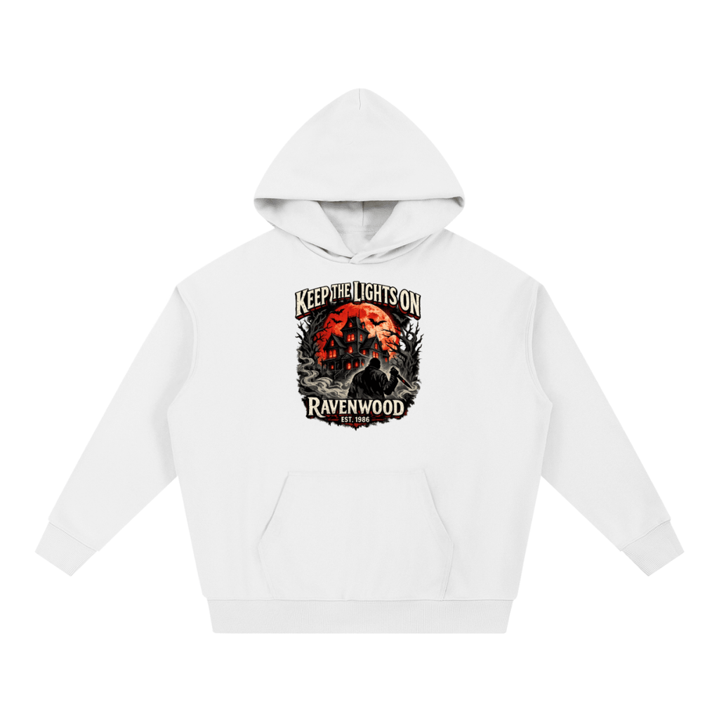 White heavyweight hoodie, front view with a haunted house, orange moon and knife-holding silhouette with Keep the Lights On and Ravenwood Est. 1986 lettering.