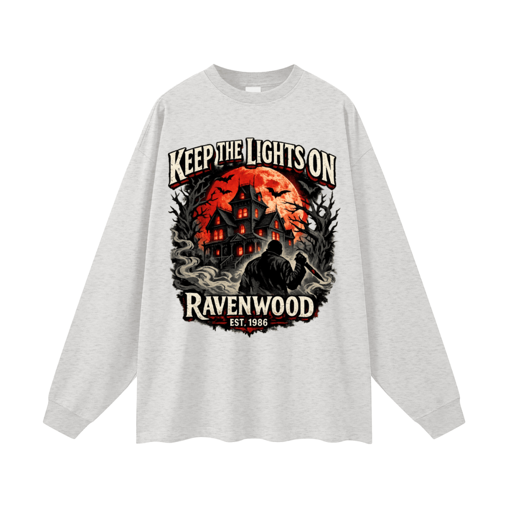 Heather gray oversized long-sleeve T-shirt, front view with a haunted house, orange moon and knife-holding silhouette with Keep the Lights On and Ravenwood Est. 1986 lettering.