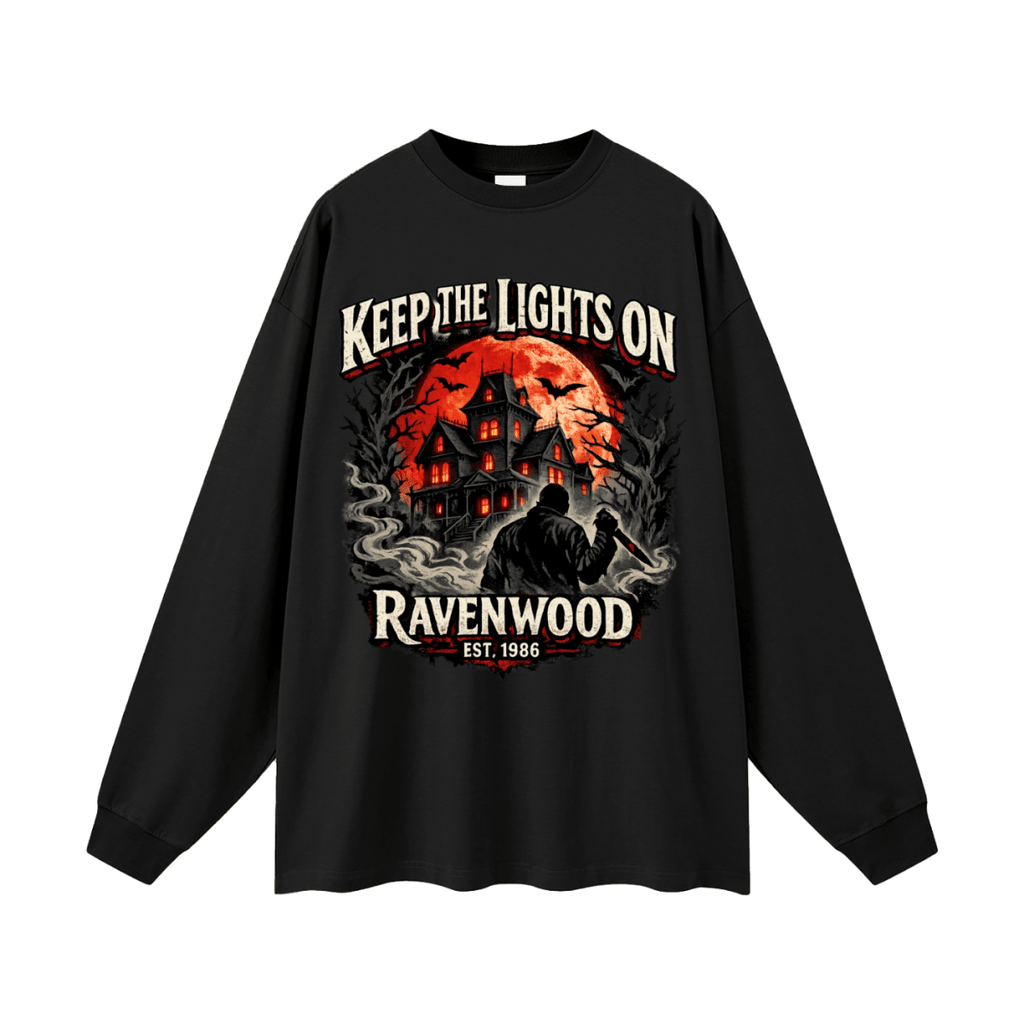Black oversized long-sleeve T-shirt, front view with a haunted house, orange moon and knife-holding silhouette with Keep the Lights On and Ravenwood Est. 1986 lettering.