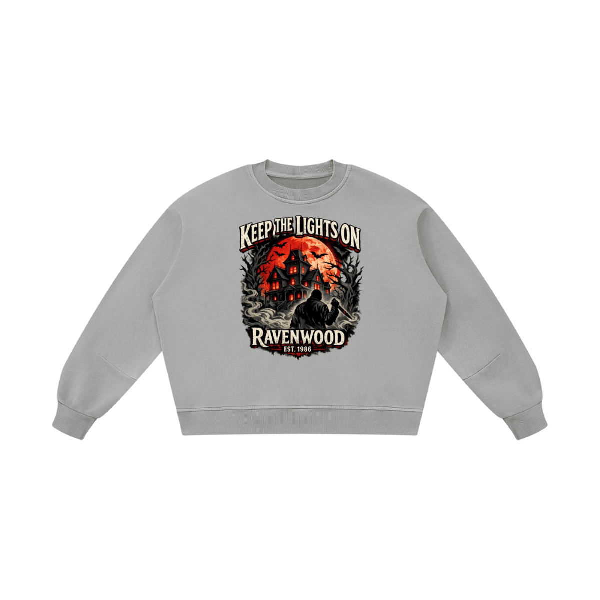 Light gray boxy vintage-washed sweatshirt, front view with a haunted house, orange moon and knife-holding silhouette with Keep the Lights On and Ravenwood Est. 1986 lettering.