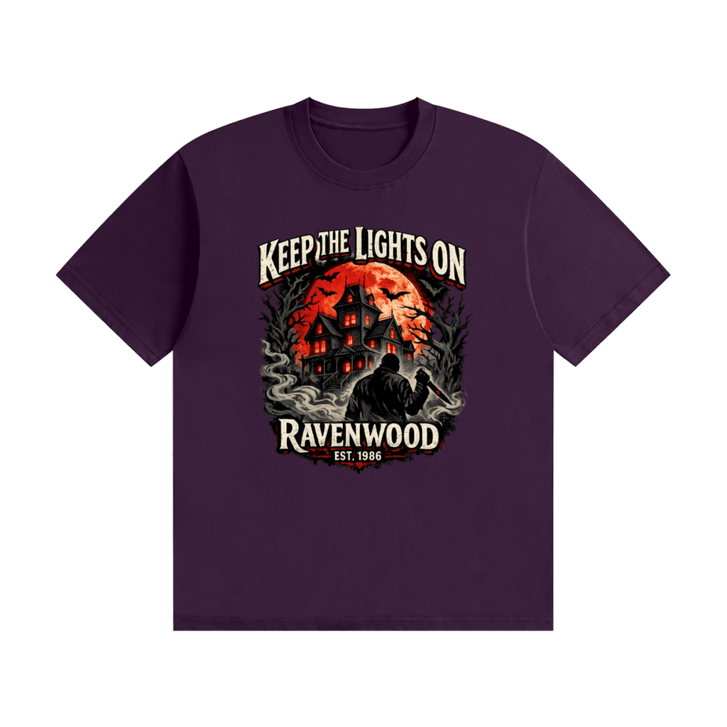 Purple cotton T-shirt, front view with a haunted house, orange moon and knife-holding silhouette with Keep the Lights On and Ravenwood Est. 1986 lettering.