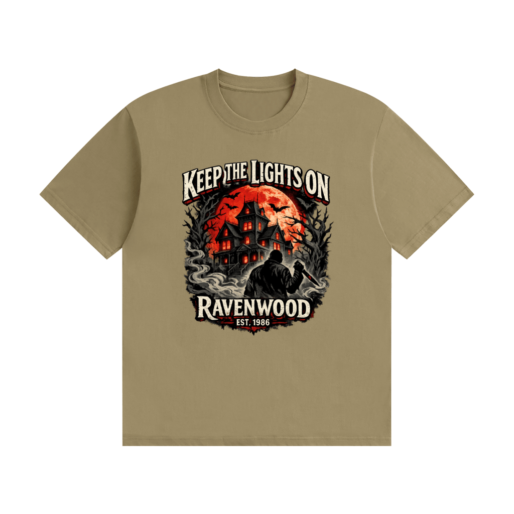 Khaki cotton T-shirt, front view with a haunted house, orange moon and knife-holding silhouette with Keep the Lights On and Ravenwood Est. 1986 lettering.