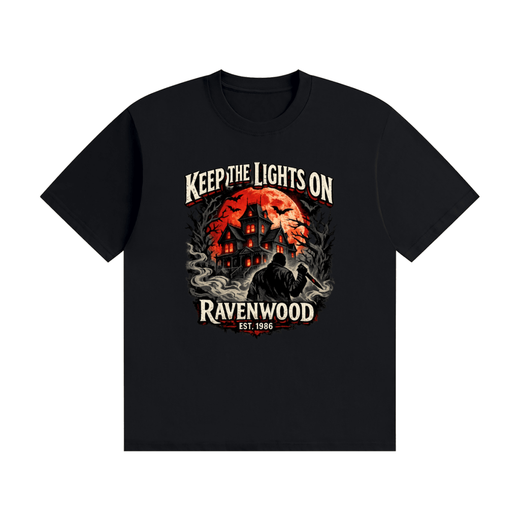 Black cotton T-shirt, front view with a haunted house, orange moon and knife-holding silhouette with Keep the Lights On and Ravenwood Est. 1986 lettering.
