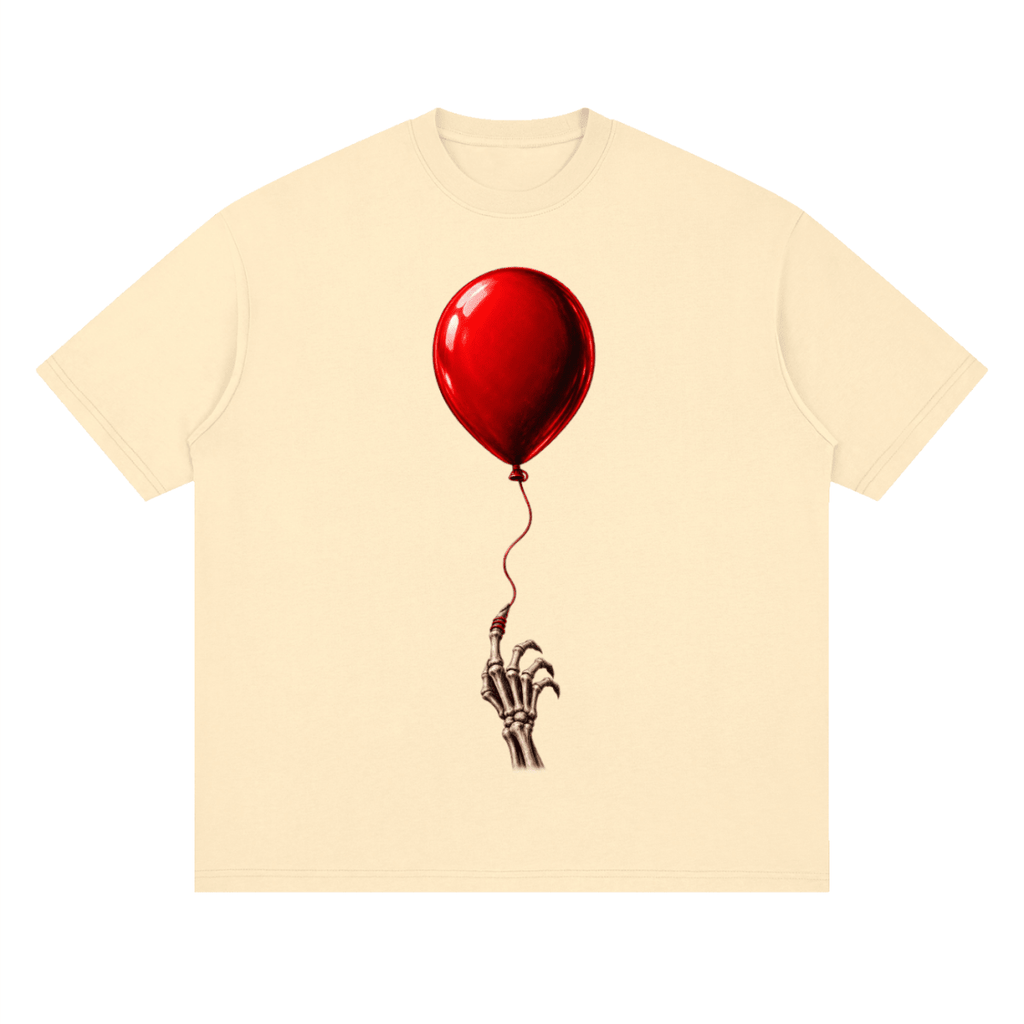 Pale yellow The Last Balloon drop shoulder T-shirt, front view with a shiny red balloon tethered to a skeletal hand.